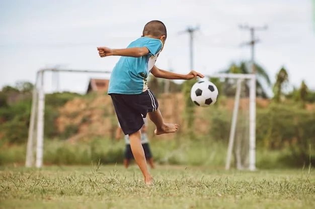 Criança praticando futebol em frente ao gol